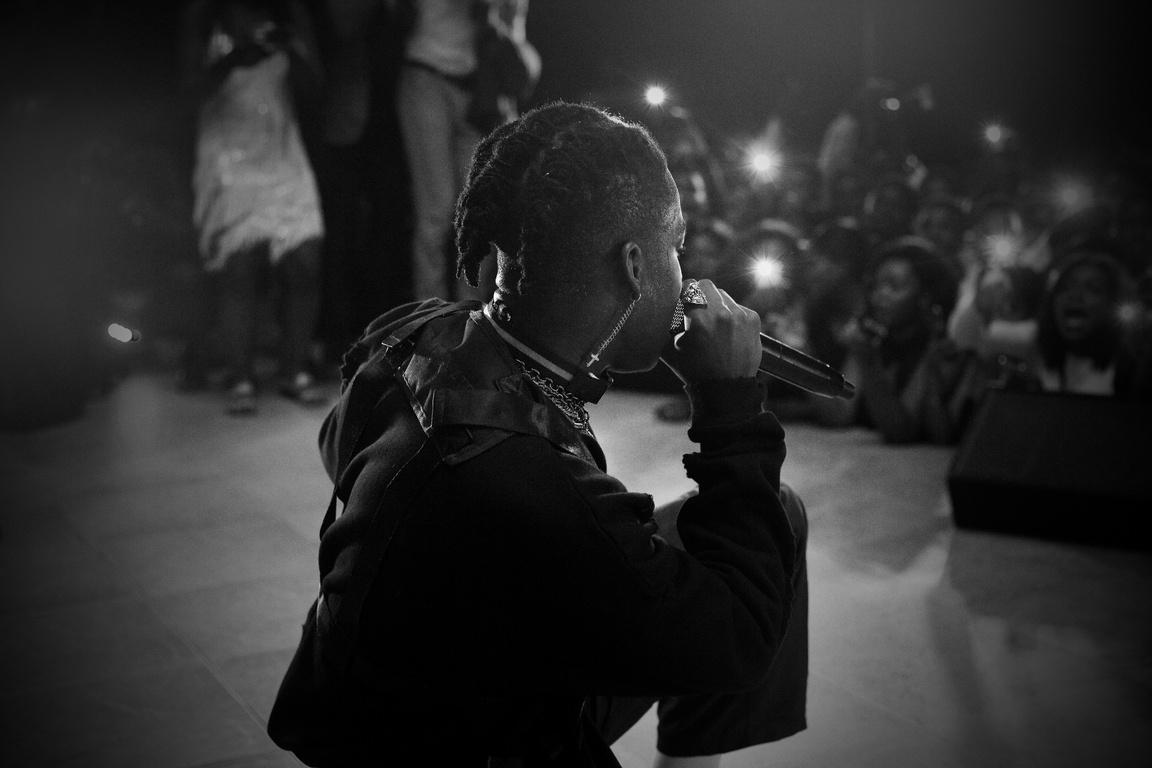 Black hip hop artist singing on stage in club